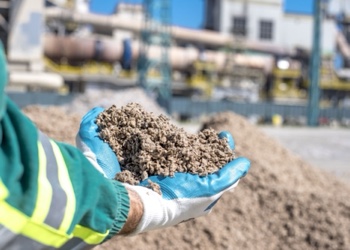 Cement raw material held in a gloved hand at a cement plant